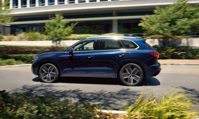 Un VW Touareg R-Line roule sur une route, vue de profil.