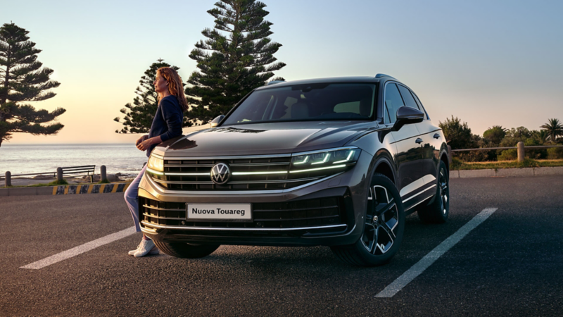 Una VW Touareg Elegance al tramonto in riva al mare con i fari a LED Matrix IQ.LIGHT HD accesi.