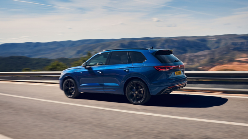 Un Touareg R bleu roule sur une autoroute.