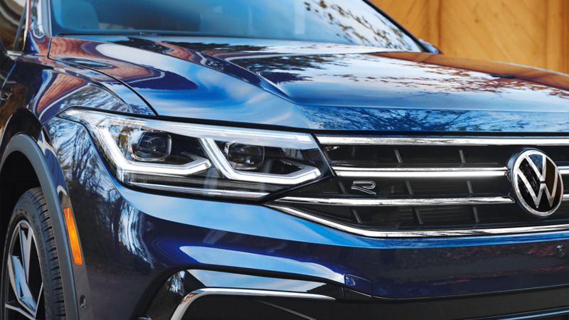 A close up photo of a grille and the front lights of the 2023 Volkswagen Tiguan 