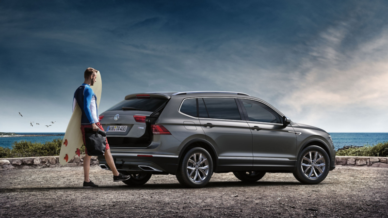 Man opens the boot of the VW tiguan Allspace with his foot under the car