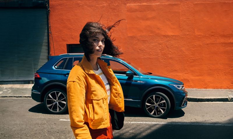 Femme aux cheveux ondulant, VW Tiguan en arrière-plan