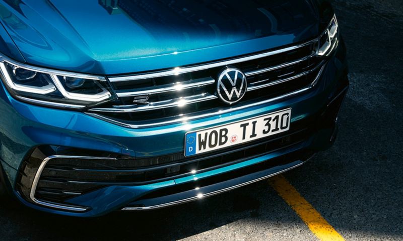 Vista frontale di VW Tiguan in blu, con particolare attenzione alla griglia del radiatore e ai fari a matrice LED IQ.LIGHT opzionali.
