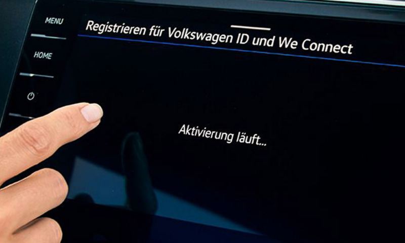 Digitalscreen mit Screen zur laufenden Registrierung für Volkswagen ID und We Connect, eine Hand bedient den Touchscreen.