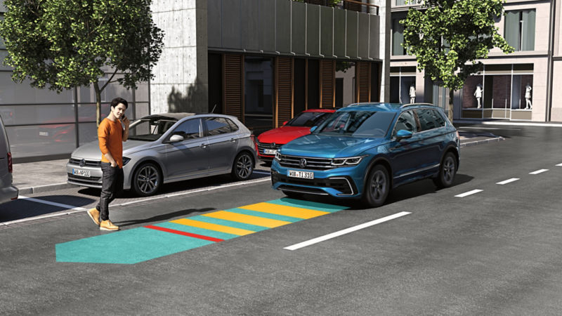 En blå VW Tiguan kører i trafikken, Front Assist anvendes.