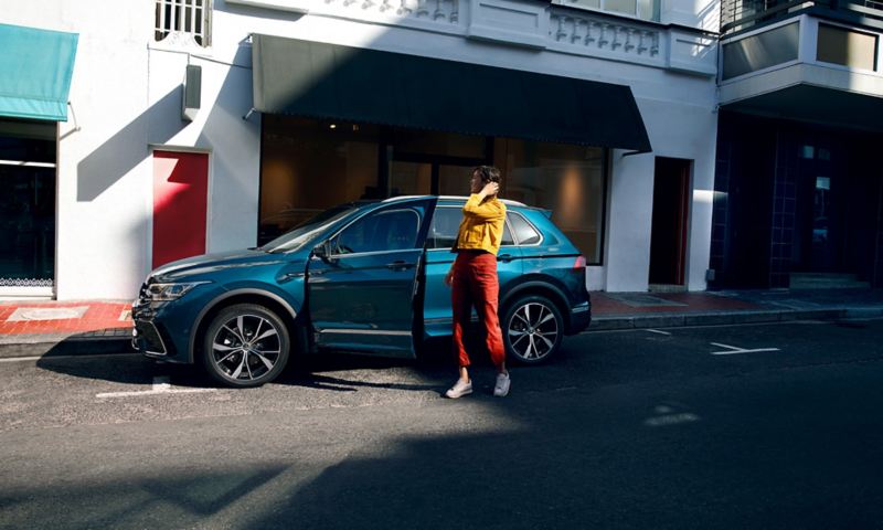 Femme près de la porte ouverte côté conducteur d'un Nouveau Tiguan