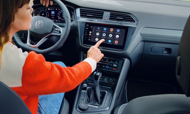 Blick auf das Infotainmentsystem im Tiguan Allspace, Abbildung von Apps im Display. Eine Frau sitzt auf dem Fahrersitz. 