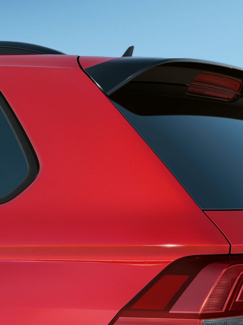 Detail of the C-pillar of a Tiguan URBAN SPORT in red, with darkened rear and side windows.