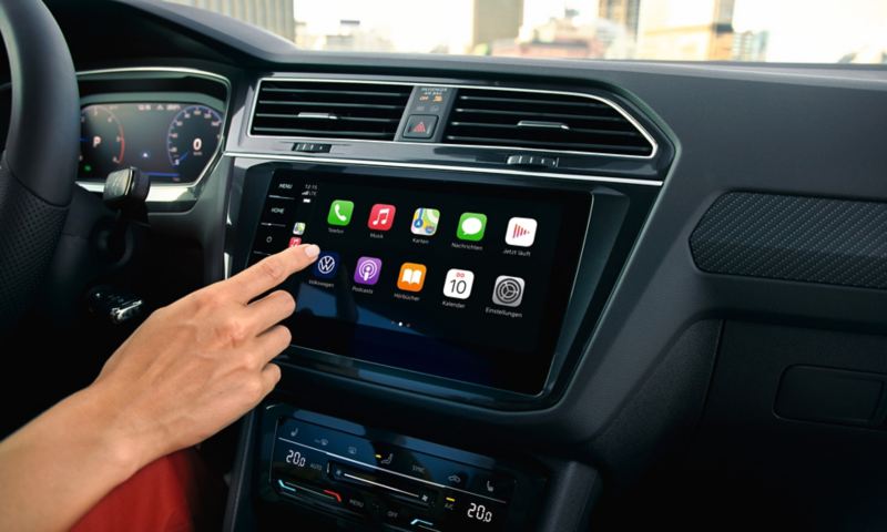 Ansicht des Cockpits mit Farbdisplay. Im Display die Anzeige der Apps, eine Hand bedient die Touch-Fläche.