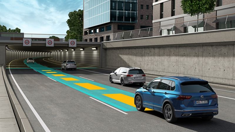 VW Tiguan blu in movimento nel traffico stradale, utilizzando il Travel Assist opzionale.