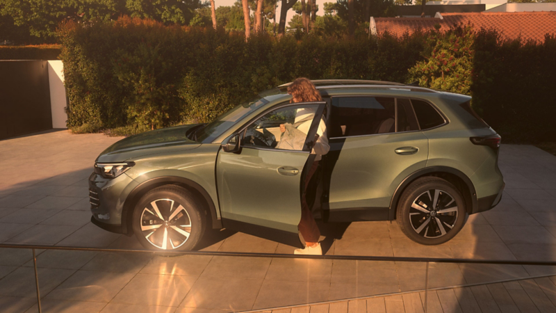 Une femme monte dans un Tiguan côté conducteur.