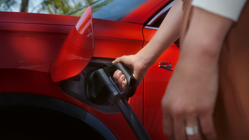 Prise de recharge branchée sur le Nouveau Tiguan eHybrid rouge.