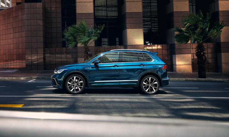 En VW Tiguan holder ved siden af et højhus med store vinduer, der kan vælges forskellige køreprofiler med 4MOTION Active Control (ekstraudstyr).