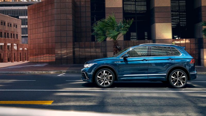 VW Tiguan è parcheggiata di traverso davanti a un grattacielo con grandi finestre; diversi profili di guida possono essere selezionati con il 4MOTION Active Control opzionale.