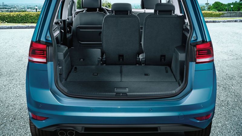 Dettaglio del bagagliaio aperto di Volkswagen Touran, vista posteriormente, con sistema 'Easy Fold', che agevola l'accesso nelle vetture con più file di sedili.