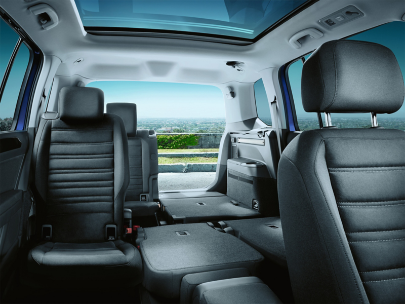 VW Touran von innen, Ansicht von Beifahrersitz nach hinten zur geöffneten Heckklappe mit teils umgeklappten Sitzen.