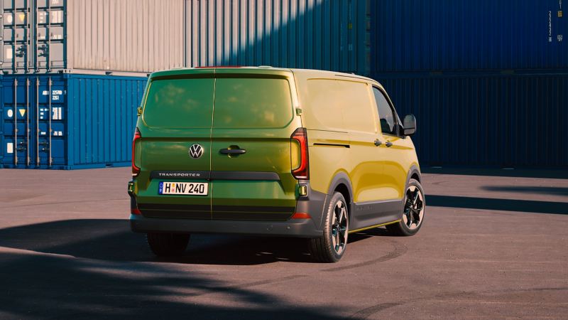 Eine Rückansicht vom VW Transporter auf einem Containerterminal.