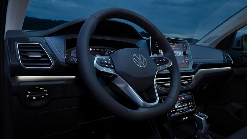 Instrumentpanelen i en VW T-Cross nattetid med fokus på den vita ambientbelysningen.