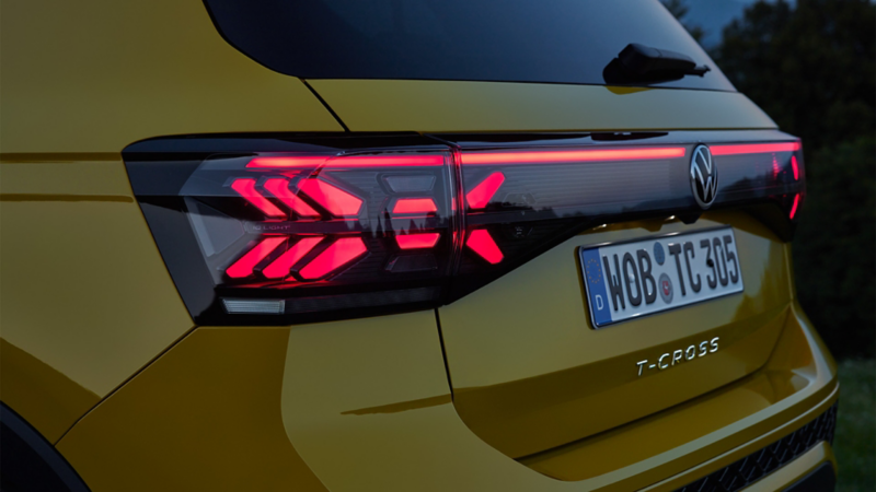 Le VW T-Cross jaune de dos, dans un paysage méditerranéen.