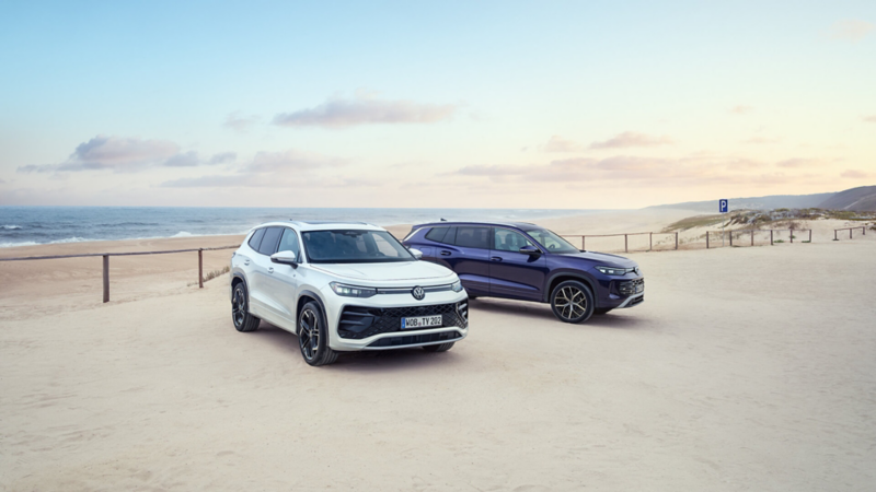 Two VW cars parked at a beach. 