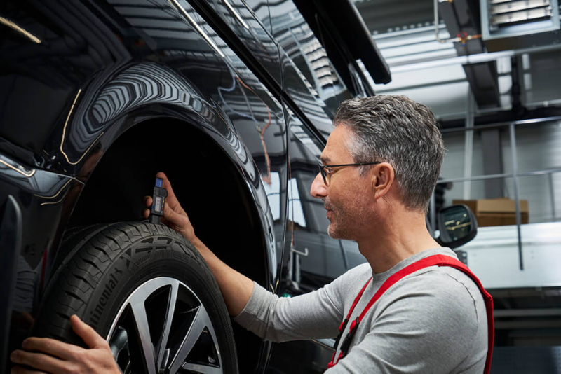 Un employé de Volkswagen travaille sur les pneus d'un véhicule Volkswagen