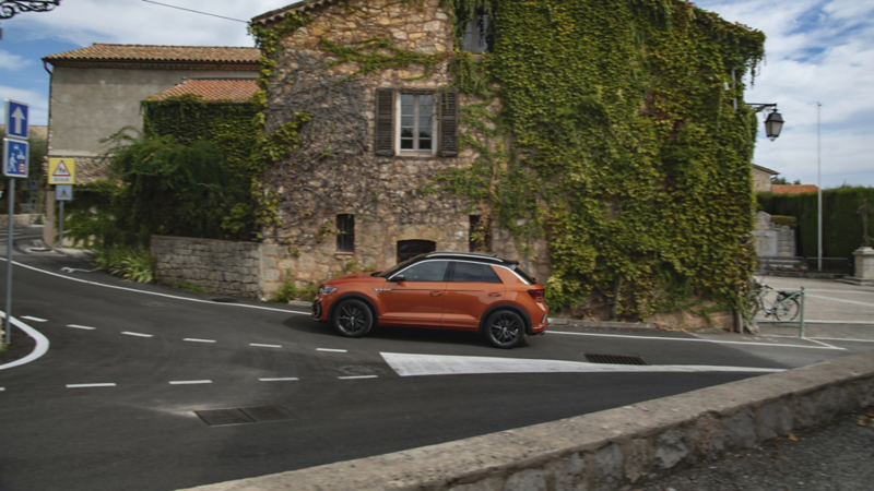 En orange t-roc kører i by