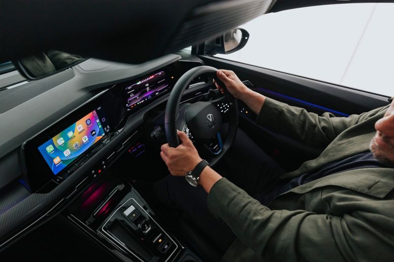 Person holding the steering wheel inside the Volkswagen Golf R