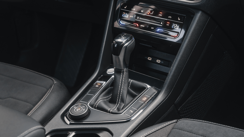 Gros plan sur la console centrale du Volkswagen Taos mettant en valeur le levier de vitesse automatique et les commandes de transmission.