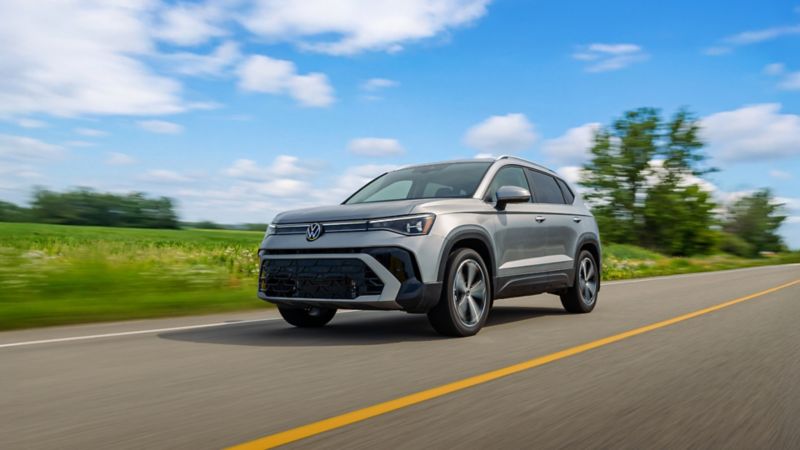 Front three-quarter view of a silver Volkswagen Taos driving on a highway