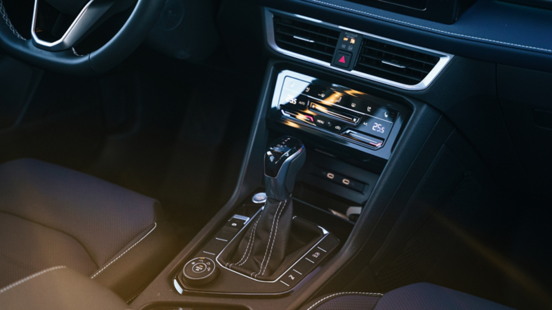Close-up of the Volkswagen Taos centre console showing the gear shifter, climate controls, and infotainment screen.