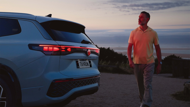 Man walking behind Tayron at dusk