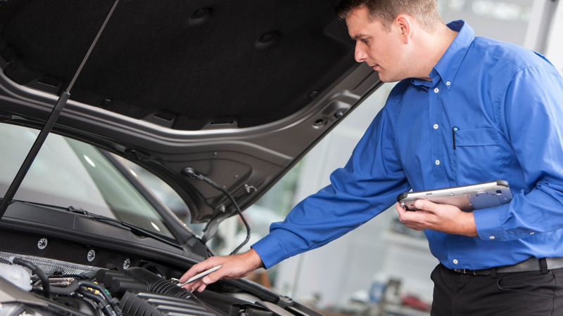 Technical expert examining van engine