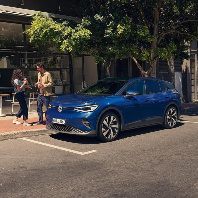 Dos personas cerca de su Volkswagen eléctrico