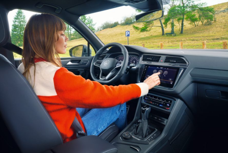 Two children sit in the interior of a Tiguan Allspace Elegance: a girl in the second row of seats, a boy in the third row. 