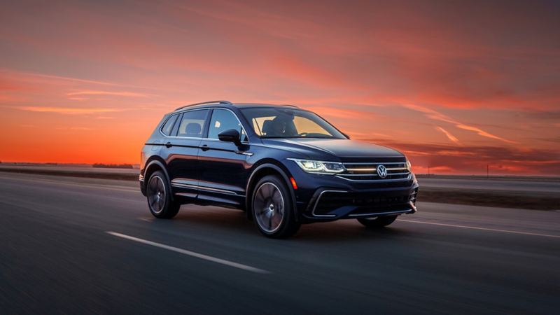 The 2024 VW Tiguan driving down a road at sunset