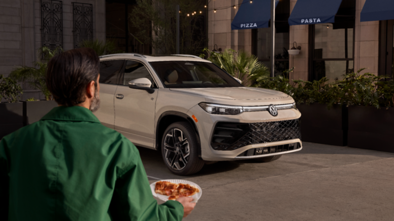 Person approaching the 2026 Volkswagen Tiguan parked outside. 