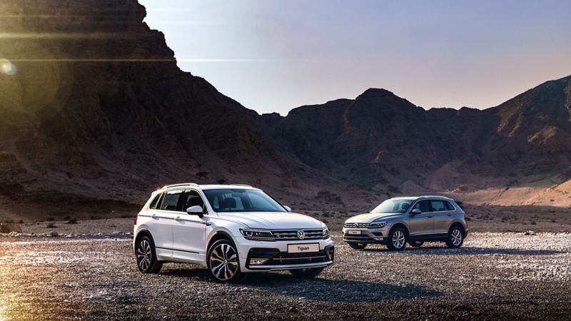 The Volkswagen Tiguan R-Line and classic parked in from of a mountain in the Middle East