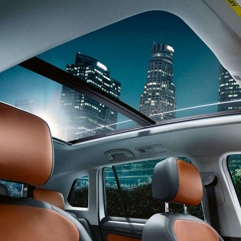 The Volkswagen Tiguan's interior with a view of the panoramic sunroof and orange seats