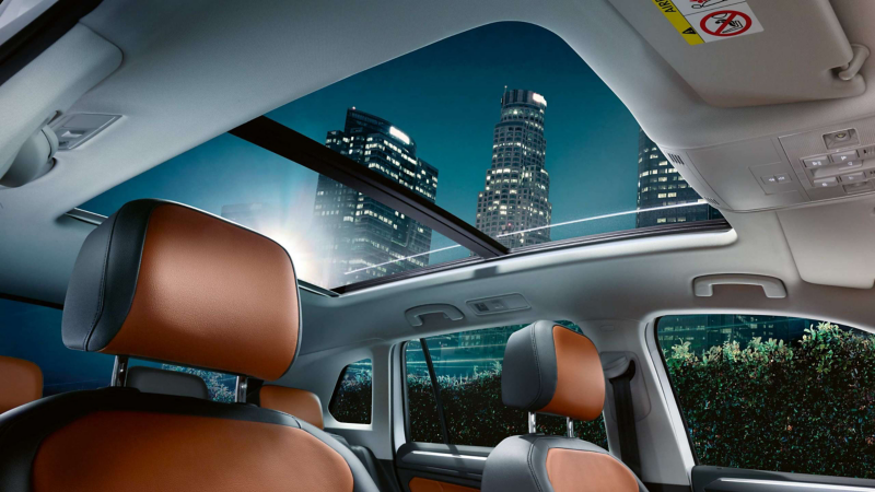 The Volkswagen Tiguan's interior with a view of the panoramic sunroof and orange seats