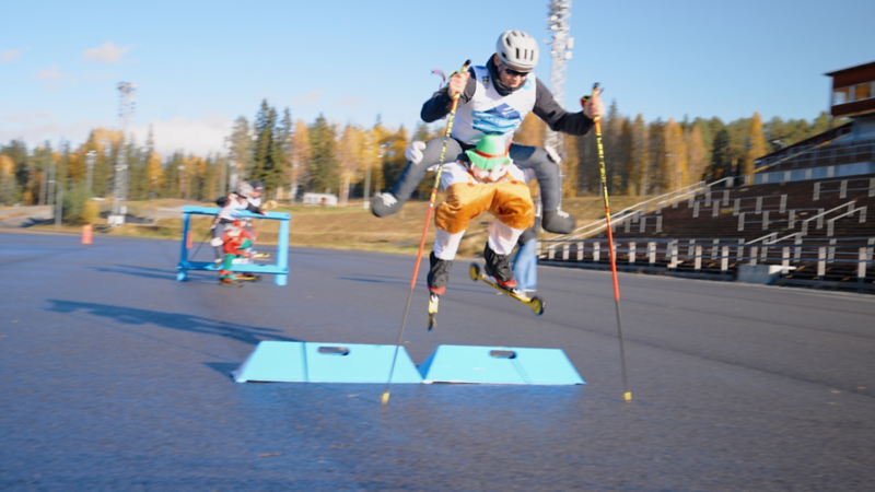 Lagen i duellen har fått på sig maskeradkläder när hinderbanan genomförs, ilden fångar en åkare i luften