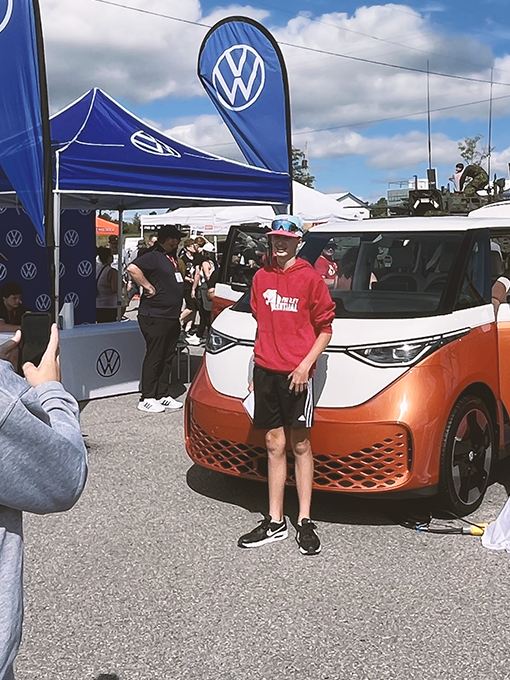 A teenager taking a photo of his friend and the Volkswagen ID. Buzz