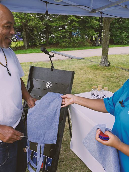A Volkswagen rep handing a man some VW swag