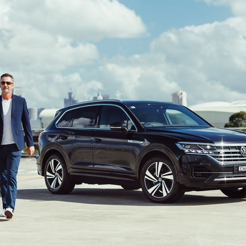 Man Walking away from Volkswagen Touareg parked on a rooftop 