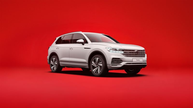 Biały VW Touareg eHybrid Plug-in na czerwonym tle.