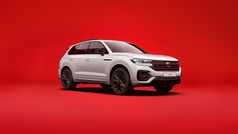 Biały VW Touareg widziany z przodu i z boku na czerwonym tle.