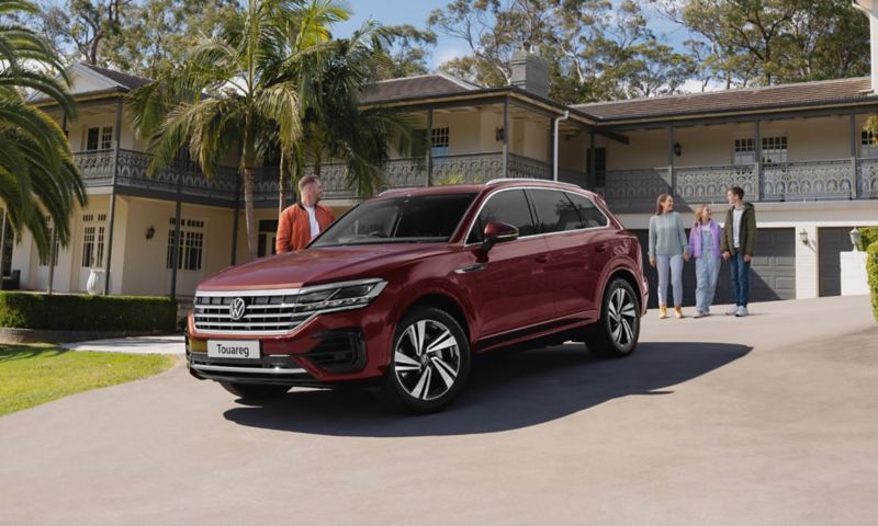 Woman and teenager next to a Volkswagen Touareg