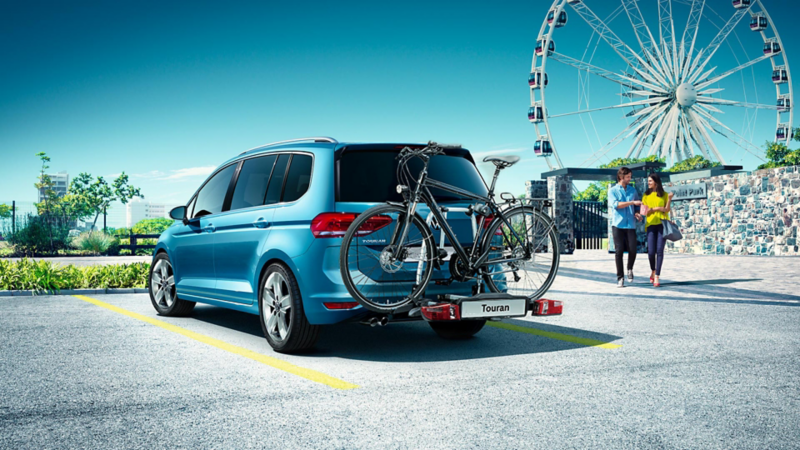 Vista 3/4 posteriore di Volkswagen Touran parcheggiata vicino a una ruota panoramica.