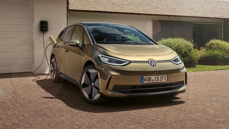 a bronze ID.3 parked at home plugged into a wall charger