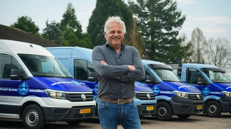 Frank Smeulders, eigenaar van Tuintechnisch Bureau Smeulders, met op de achtergrond het actuele wagenpark aan Volkswagen Crafters