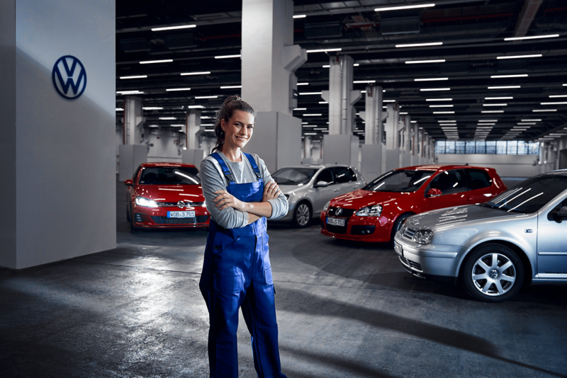 Pracownik serwisu przed trzema różnymi modelami volkswagena
